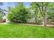 A lush backyard with mature trees and landscaping, alongside a brick pathway at 6105 W Long Dr, Littleton, CO 80123