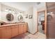 Bathroom featuring a double vanity, lots of lighting and a doorway to another room at 6105 W Long Dr, Littleton, CO 80123