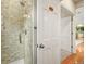 Bathroom boasting a glass-enclosed shower with subway tile and a white door to another room at 6105 W Long Dr, Littleton, CO 80123