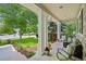 Inviting covered porch with comfortable seating, stone accents, and views of the landscaped front yard at 6105 W Long Dr, Littleton, CO 80123