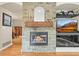 Living room stone fireplace with a wood mantle, gas logs, and hearth at 6105 W Long Dr, Littleton, CO 80123