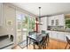 Eat-in kitchen features stainless appliances, white cabinetry, and patio access to an outdoor grill and seating at 6105 W Long Dr, Littleton, CO 80123