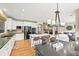 Bright kitchen with stainless appliances, eat-in island, hardwood flooring, and access to the living room at 6105 W Long Dr, Littleton, CO 80123