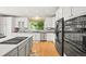 Kitchen boasts white cabinets, stainless appliances, island and hardwood flooring at 6105 W Long Dr, Littleton, CO 80123