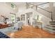 Bright, open living room with hardwood floors, a grand staircase, and large windows at 6105 W Long Dr, Littleton, CO 80123