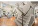 Spacious living room with hardwood floors, a staircase, and large windows offering natural light at 6105 W Long Dr, Littleton, CO 80123