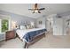 Bright main bedroom features neutral walls, plush carpeting, a ceiling fan, and an ensuite bathroom at 6105 W Long Dr, Littleton, CO 80123