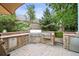 Entertain in style with this outdoor kitchen that is equipped with a stainless steel grill, storage, and stone accents at 6105 W Long Dr, Littleton, CO 80123