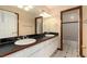 This bathroom offers double sinks, framed mirrors, and modern fixtures with a shower and tub at 1120 Antelope W Dr, Bennett, CO 80102