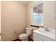 Convenient half bath features a sink, toilet, and window providing natural light at 1120 Antelope W Dr, Bennett, CO 80102