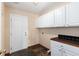 This laundry room offers tile flooring, lots of cabinets, and counter space with a door to the outside at 1120 Antelope W Dr, Bennett, CO 80102