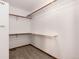 This walk-in closet features carpet and wooden storage racks and bars for ample clothing storage at 1120 Antelope W Dr, Bennett, CO 80102