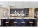 Gorgeous kitchen boasts black cabinetry, pendant lighting, granite counters, and a spacious island with seating for four at 24322 E Mineral Dr, Aurora, CO 80016