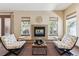 Cozy living room with decorative fireplace, comfortable chairs, natural lighting, and view to the outside at 24322 E Mineral Dr, Aurora, CO 80016