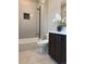 Clean white bathroom with a tiled shower-tub combo, accented with a dark, contemporary cabinet and quartz countertop at 2879 W Parkside Pl, Denver, CO 80221