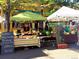 An outdoor farmer's market with signs, fruits, vegetables, and various local products at 2879 W Parkside Pl, Denver, CO 80221