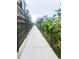 An outdoor view of a community garden pathway lined with vibrant sunflowers and a privacy fence at 2879 W Parkside Pl, Denver, CO 80221