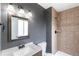 A bathroom featuring a vanity with a wooden frame mirror and a tiled shower area at 16652 E Gunnison Pl, Aurora, CO 80017