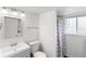 Bright bathroom featuring a vanity, toilet, shower with a rainbow shower curtain, and window at 16652 E Gunnison Pl, Aurora, CO 80017