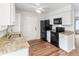 Updated kitchen boasts granite countertops, sleek black appliances, and ample white cabinetry at 16652 E Gunnison Pl, Aurora, CO 80017
