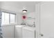 Bright laundry room featuring side-by-side washer and dryer units and a storage shelf at 16652 E Gunnison Pl, Aurora, CO 80017