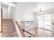 Carpeted staircase with wood railing, leading to a bright upstairs area and outdoor access at 16652 E Gunnison Pl, Aurora, CO 80017