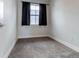 A carpeted bedroom with a window and dark curtains at 2350 Tremont Pl # 19, Denver, CO 80205