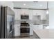 Bright kitchen features stainless steel appliances and modern white cabinetry at 2350 Tremont Pl # 19, Denver, CO 80205