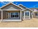 Exterior of new home with covered patio, slider, and hardie plank siding at 19060 E 96Th Pl, Commerce City, CO 80022