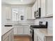 Modern kitchen featuring stainless steel appliances, quartz countertops, and white cabinetry, offering a stylish and efficient space at 19060 E 96Th Pl, Commerce City, CO 80022
