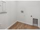 A clean laundry room featuring wood-look flooring with white walls, and washer/dryer hookups at 19060 E 96Th Pl, Commerce City, CO 80022