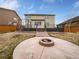 Backyard with patio, fire pit, and deck with black metal railings from the main level at 8236 E 137Th Dr, Thornton, CO 80602