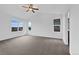 Spacious bedroom with three windows, neutral carpet, and a ceiling fan at 8236 E 137Th Dr, Thornton, CO 80602