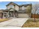 Charming two-story home featuring a red front door, stone accents, and a well-maintained lawn at 8236 E 137Th Dr, Thornton, CO 80602