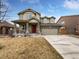 Charming two-story home featuring a red front door, stone accents, and a well-maintained lawn at 8236 E 137Th Dr, Thornton, CO 80602
