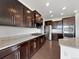 Modern kitchen featuring stainless steel appliances, granite countertops, and dark wood cabinets at 8236 E 137Th Dr, Thornton, CO 80602