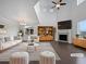Bright, staged living room with high ceilings, a fireplace, and stylish, neutral-toned furniture at 8236 E 137Th Dr, Thornton, CO 80602