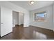 Bright room with hardwood floors, white trim, and large windows offering natural light at 8236 E 137Th Dr, Thornton, CO 80602