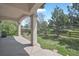 Covered porch with stone columns overlooks a fenced yard with mature trees at 16043 Bridle Ridge Dr, Monument, CO 80132