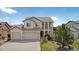 Charming stucco two-story home featuring a three-car garage, well-manicured lawn, and inviting arched entryway at 16043 Bridle Ridge Dr, Monument, CO 80132