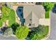 Aerial view of a well-manicured home featuring a lush lawn, a spacious patio, mature trees, and a well-kept roof at 8427 S Parfet Ct, Littleton, CO 80127