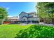 Beautifully landscaped backyard featuring a well-maintained lawn, mature trees, a patio, and privacy fencing at 8427 S Parfet Ct, Littleton, CO 80127