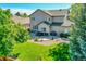 Expansive backyard with a well-maintained lawn, a patio area with seating, and mature trees for shade and privacy at 8427 S Parfet Ct, Littleton, CO 80127