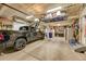 Well-lit garage with epoxy flooring, overhead storage rack, and ample space for parking a truck and storage at 8427 S Parfet Ct, Littleton, CO 80127
