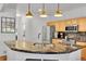Kitchen island with granite countertop, pendant lighting, and stainless steel appliances at 8427 S Parfet Ct, Littleton, CO 80127