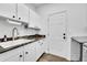 Laundry room with white cabinets, granite countertops, and stainless steel appliances at 8427 S Parfet Ct, Littleton, CO 80127