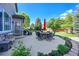 Cozy patio area with outdoor seating, a table, and a grill, surrounded by beautiful landscaping and lush greenery at 8427 S Parfet Ct, Littleton, CO 80127