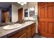 Bathroom featuring dual sinks with decorative mirrors, warm wood cabinets, and tile flooring at 283 Yank Ct, Lakewood, CO 80228