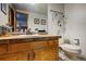 Bathroom featuring a vanity with a mosaic tile backsplash and framed mirror, plus a toilet with decorative accents at 283 Yank Ct, Lakewood, CO 80228