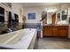 Bathroom featuring a luxurious white jacuzzi tub with tile accents and dual sinks at 283 Yank Ct, Lakewood, CO 80228